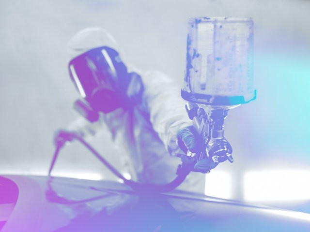 Technician spray-painting a car panel at Glenside Smash Repairs